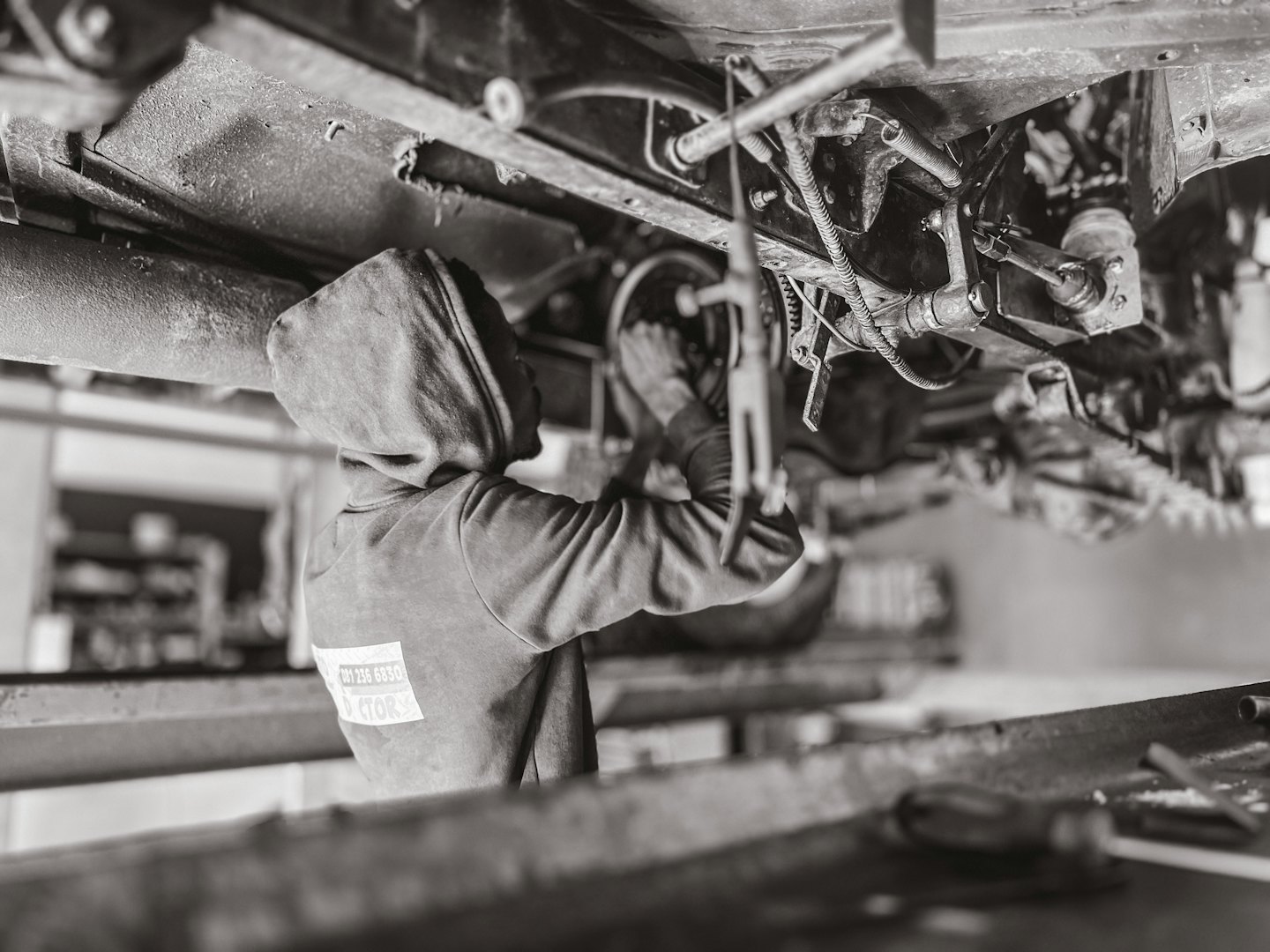 Mecánico debajo de un coche en un elevador en un taller de reparación.