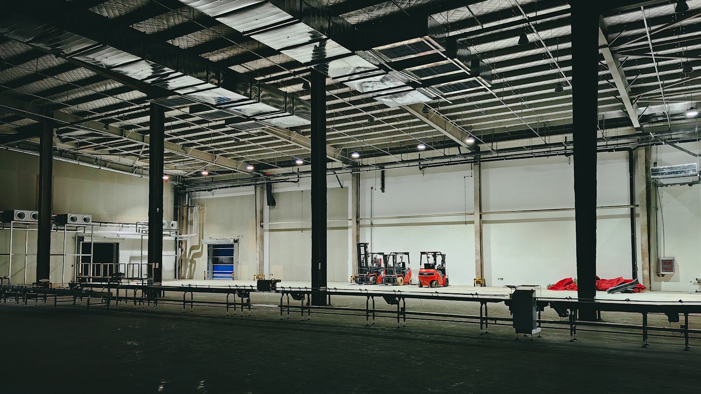 Carretillas elevadoras rojas aparcadas en un almacén industrial moderno.